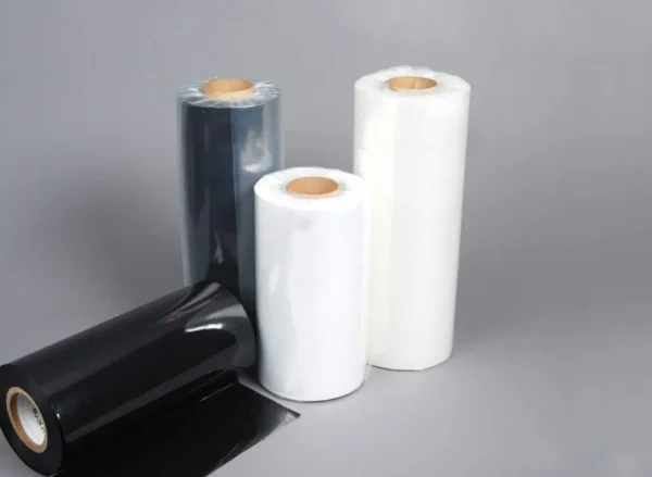 Three rolls of black and white plastic film on a grey background.